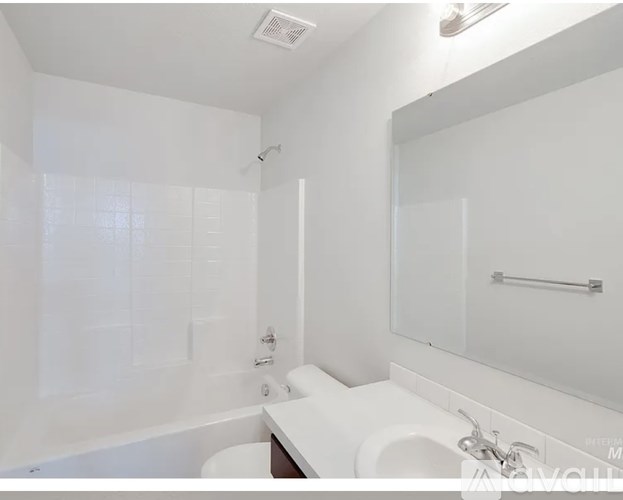 A white bathroom with a toilet, sink, and bathtub.