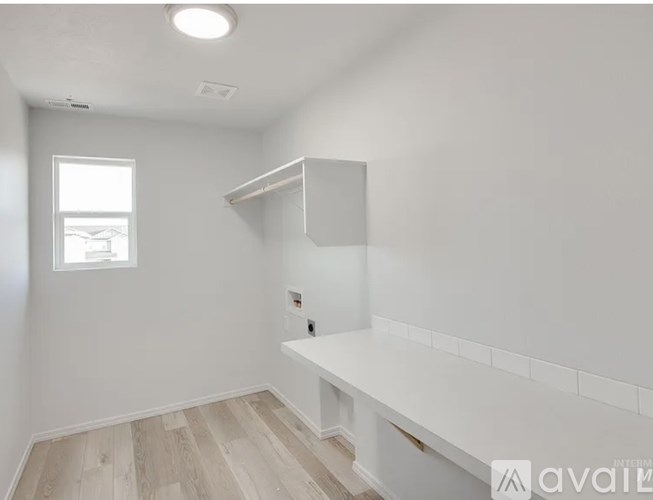 A white room with a window and a shelf.