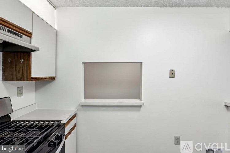 A kitchen with a stove top oven and a window.