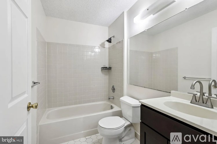 A white bathroom with a tub, toilet and sink.
