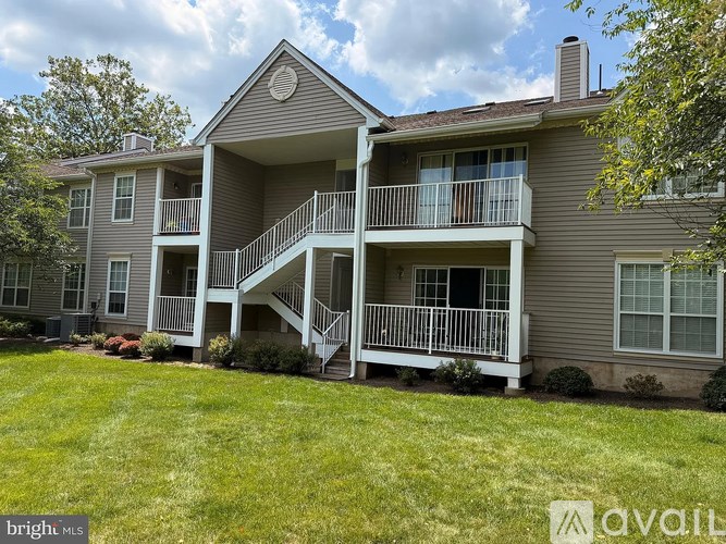 A two-story house with a balcony and a staircase leading to the second floor.