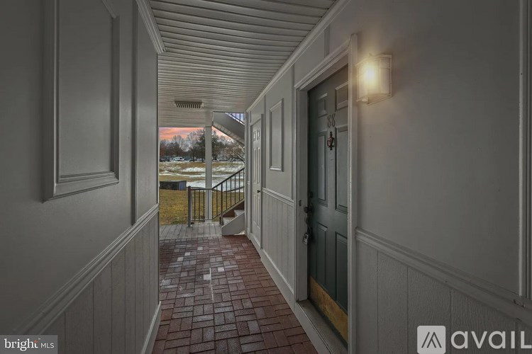 A hallway with a tiled floor and white walls.