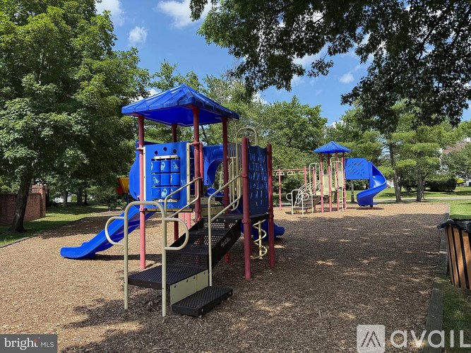 A playground with a blue slide and a red and blue play structure.