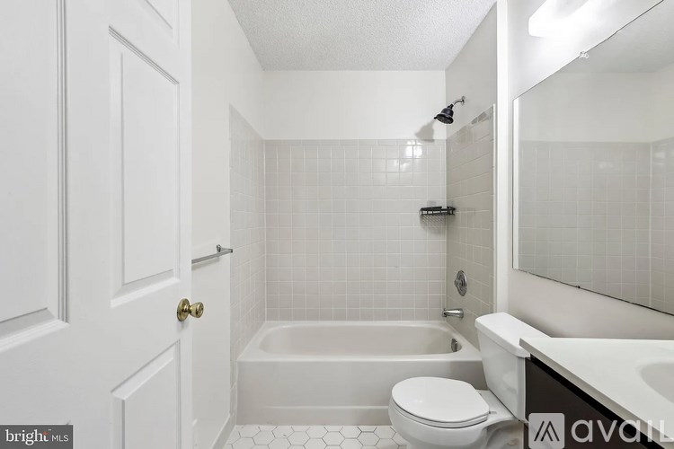 A white bathroom with a tub, toilet and sink.