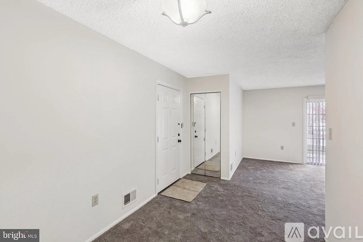 A room with a carpeted floor and a door leading to a balcony.