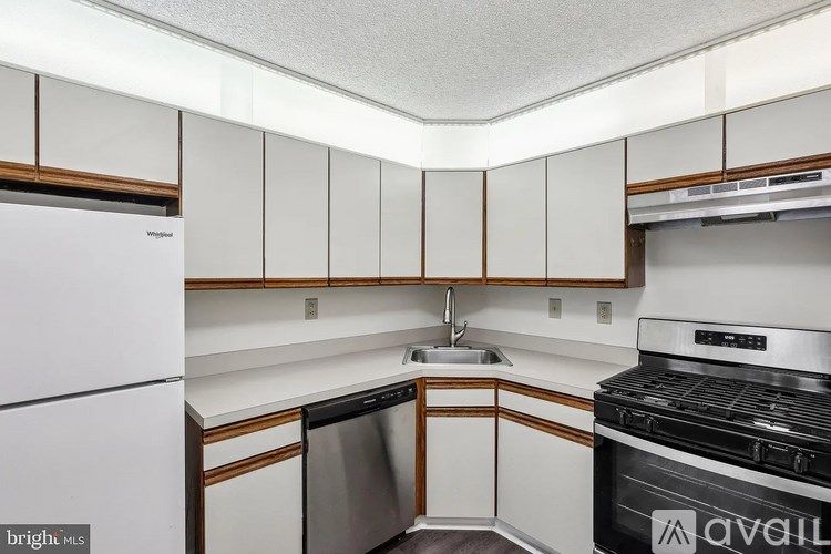 A kitchen with white cabinets and a white fridge.
