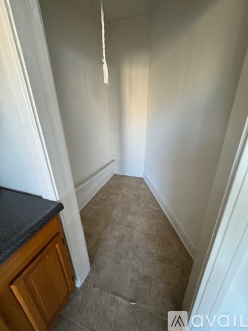 A hallway with a tiled floor and white walls.