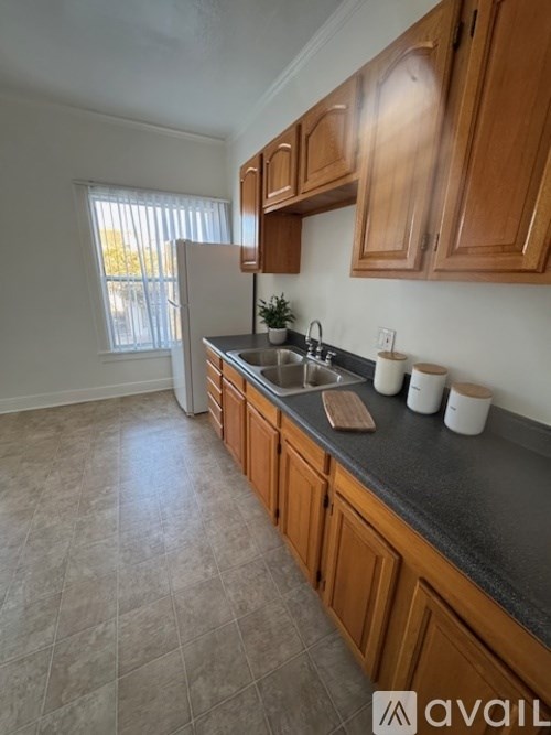 A kitchen with wooden cabinets and a tiled floor.