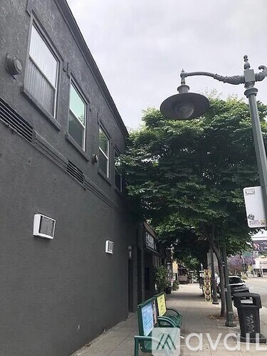A street view with a building on the left and a lamp post on the right.