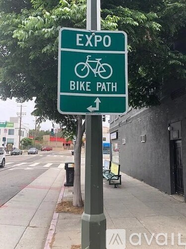 A green sign with a bicycle symbol and the words EXPO BIKE PATH pointing to the right.