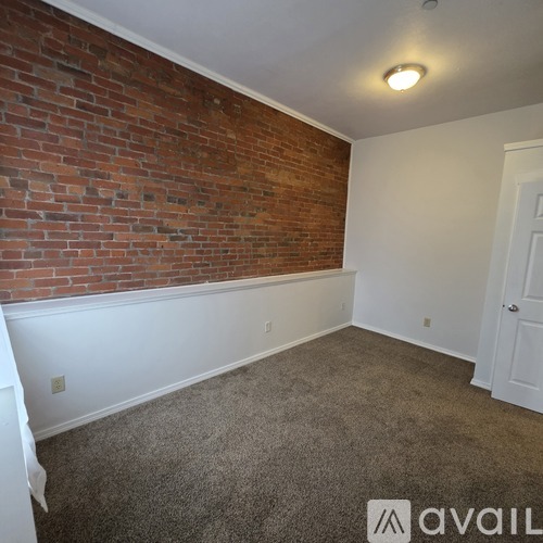 A spacious room with a carpeted floor and a mirror on the wall.