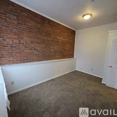 A spacious room with a carpeted floor and a mirror on the wall.