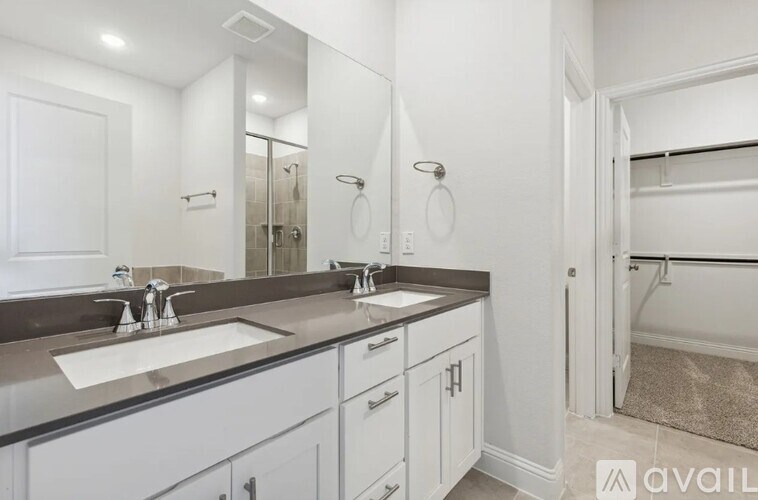 A bathroom with a sink, mirror, and towel rack.