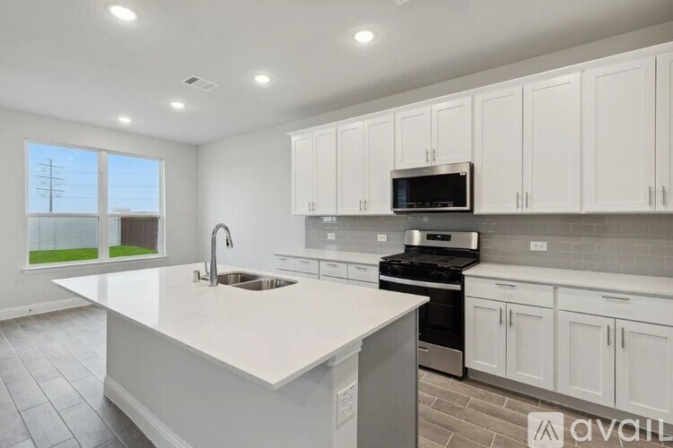 A kitchen with white cabinets and a large island.