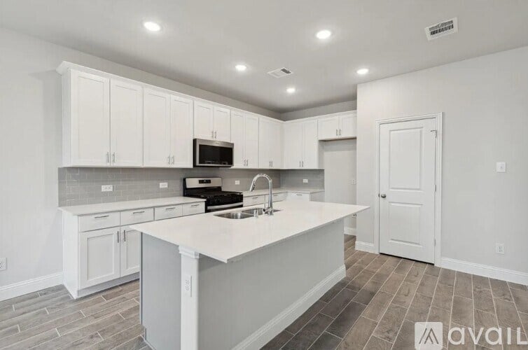A kitchen with white cabinets and a central island.