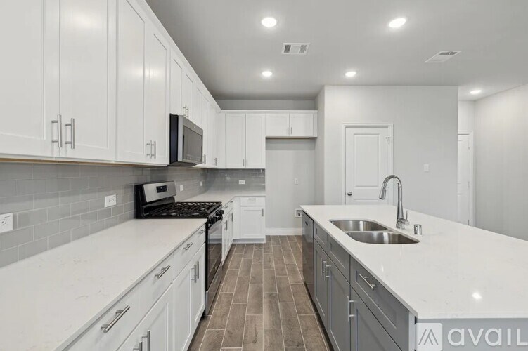 A kitchen with white cabinets and a grey counter top.