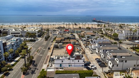 A red marker is placed on a building in the middle of a beachfront town.