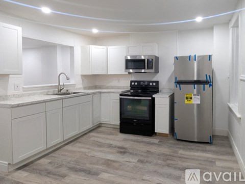 A kitchen with white cabinets and a black stove top oven.