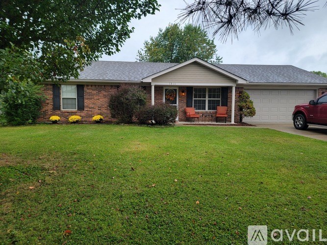A house with a red car parked in the driveway.
