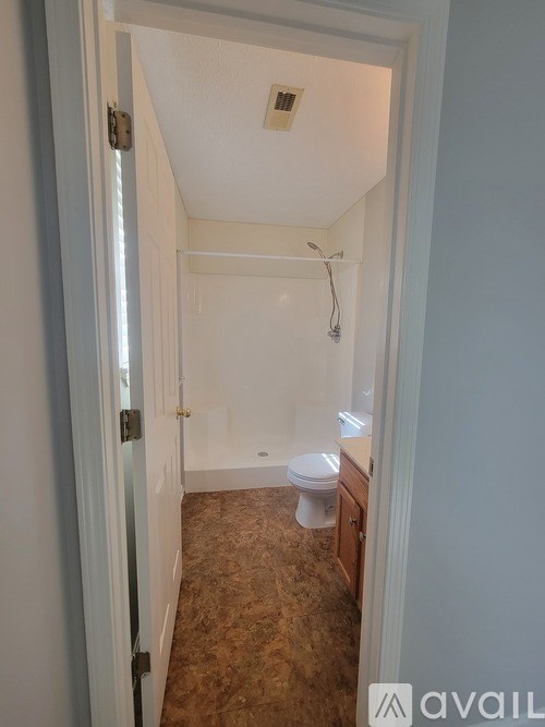 A bathroom with a toilet, sink, and shower.