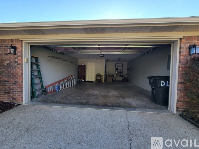 A garage with a ladder and a trash bin is available for rent.
