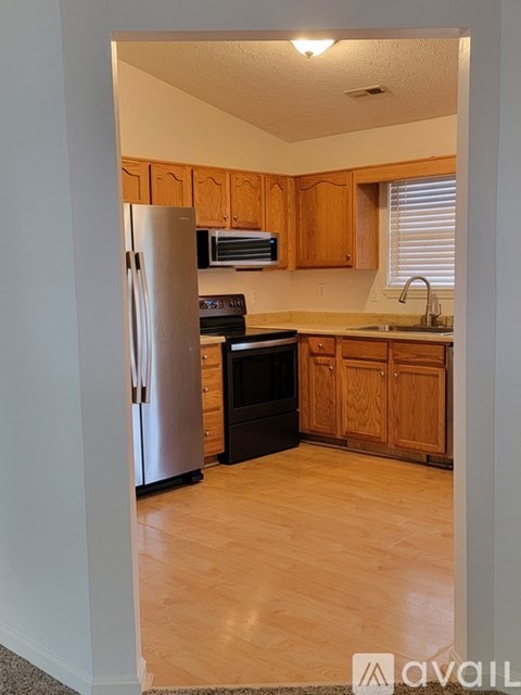 A kitchen with wooden cabinets and a stainless steel refrigerator.
