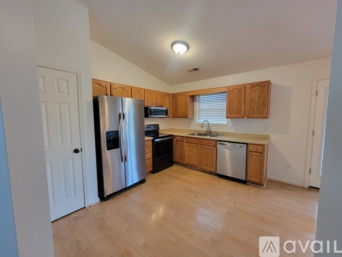 A kitchen with wooden cabinets and a stainless steel refrigerator.