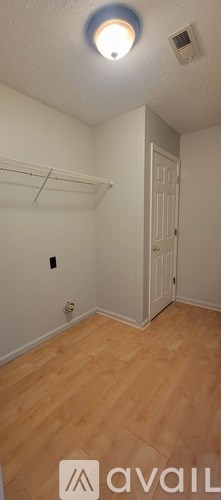 A room with a wooden floor and a white door.