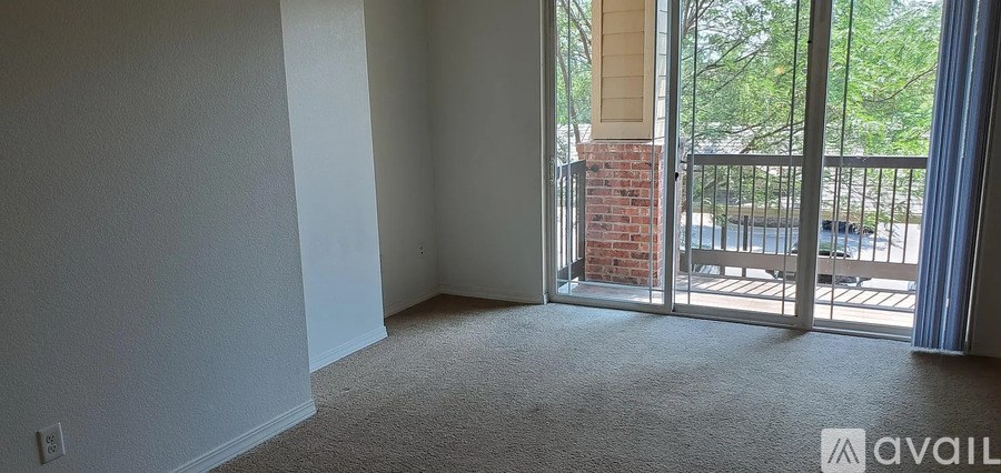 A room with a carpeted floor and a balcony with a railing.