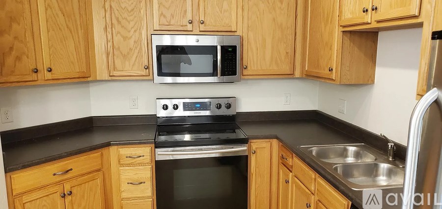 A kitchen with wooden cabinets and a stove top oven.