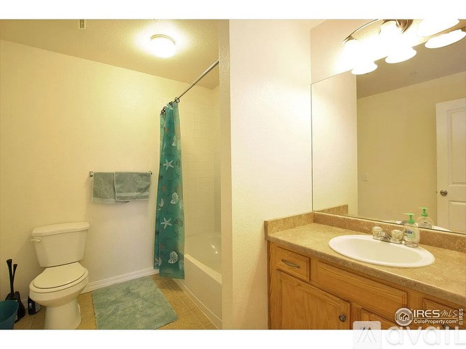 A bathroom with a toilet, sink, and shower.