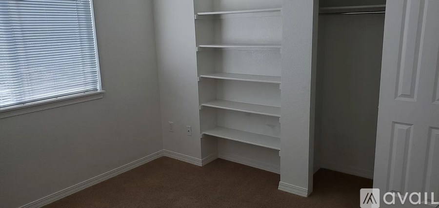 A room with a window and a shelf in it.
