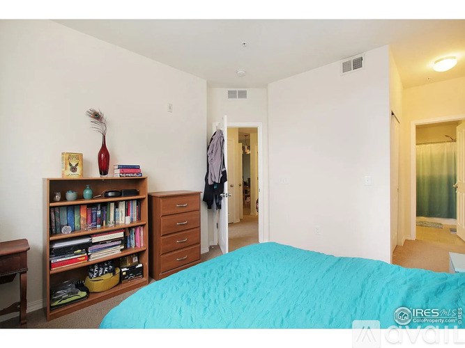 A bedroom with a bed, bookshelf, and a window.