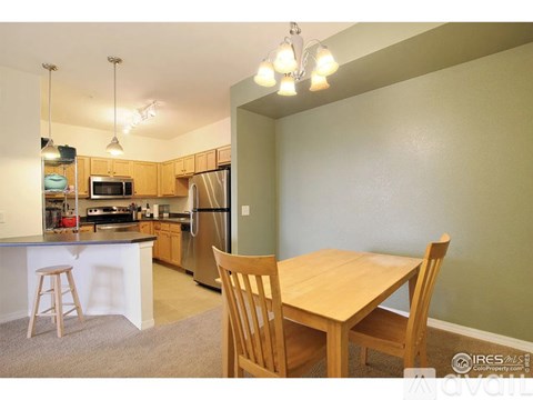 A kitchen with a table and chairs in front of a green wall.