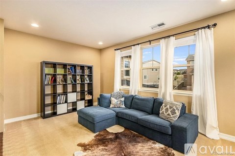 A living room with a blue sofa and a bookshelf.