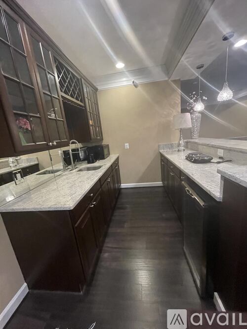 A kitchen with dark wood cabinets and a marble countertop.