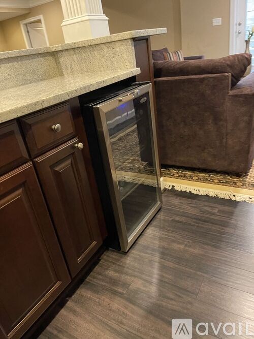 A kitchen with a refrigerator and wooden cabinets.