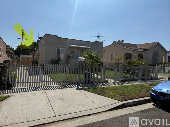 A house with a fence and a car parked in front.