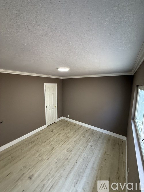 A room with a wooden floor and a white door.