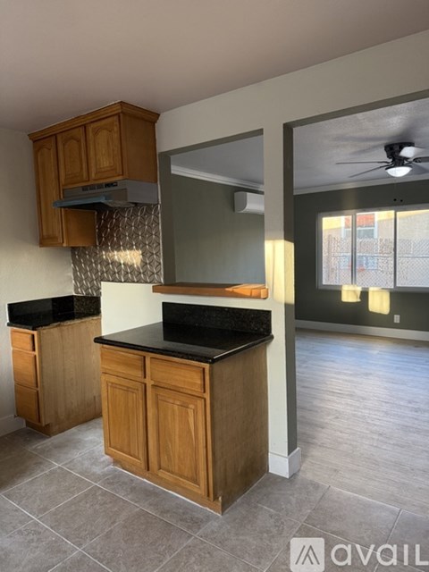A kitchen with wooden cabinets and a black countertop.