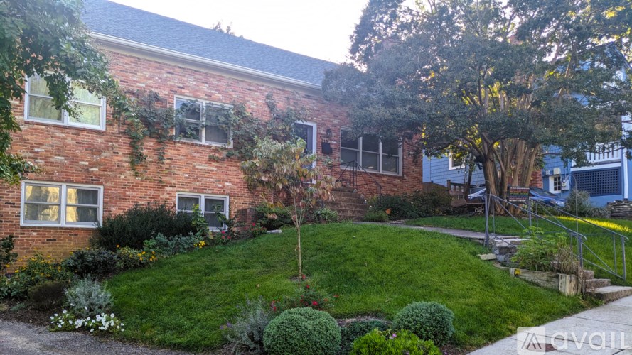 A red brick house with a green lawn in front.
