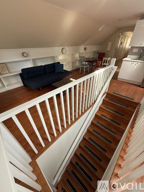 A living room with a couch and a staircase.