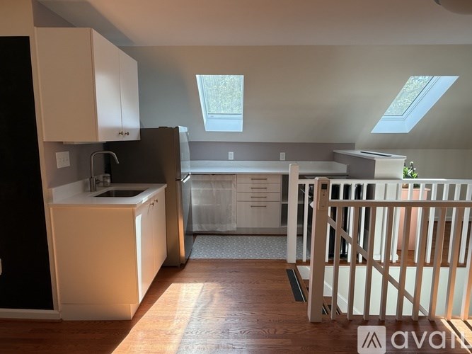 A kitchen with white cabinets and a black refrigerator.