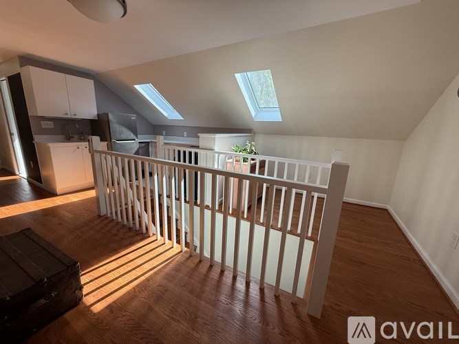 A room with wooden floors and a skylight in the ceiling.