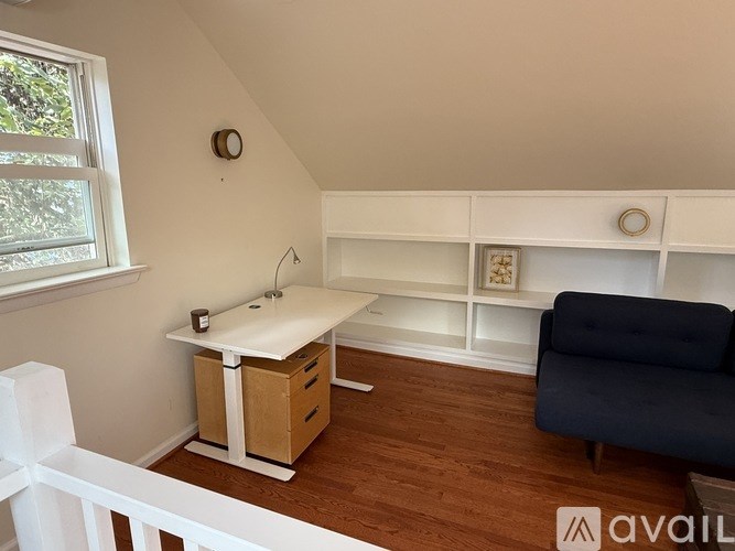 A small room with a sink, a window, and a couch.