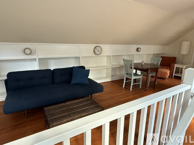 A living room with a blue couch and a white railing.