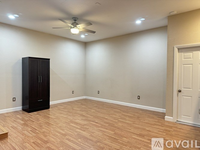 A room with a black cabinet and a ceiling fan.