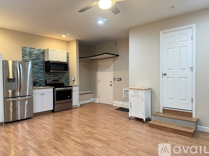 A kitchen with a refrigerator, oven, and microwave.
