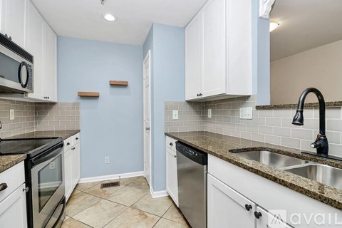 A kitchen with white cabinets and a black stove top oven.