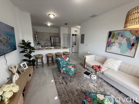 A living room with a white couch and a painting on the wall.